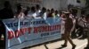 A police officer stops a group of Indians protesting against the arrest of Devyani Khobragade, an Indian consular officer in New York, outside the U.S consulate in Hyderabad, India, Dec. 16, 2013.