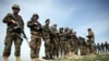 FILE - Afghan National Army soldiers stand guard following weeks of heavy clashes to recapture the area from Taliban militants in Dahna-e-Ghori district, Baghlan province, Afghanistan, March 15, 2016. But Taliban fighters retook the district in early August.