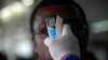 A health worker takes a passenger's temperature with an infrared digital laser thermometer at the Felix Houphouet Boigny international airport in Abidjan, Ivory Coast, Aug. 13, 2014. 