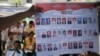 People watch as electoral officials show ballot papers during vote counting at a polling station in Jakarta, April 9, 2014. 