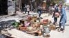 Afghan shopkeepers try to recover items from burning shops after a Taliban attack in Ghazni city, Afghanistan, Aug. 14, 2018.