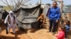 FILE - A municipal worker sanitizes a Syrian refugee camp to combat the spread of coronavirus, in Marjayoun, Lebanon, March 23, 2020.