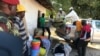Des déplacés internes et des riverains déchargent des biens de première nécessité, de la nourriture et des couvertures à Naunde, au nord du Mozambique, le 13 juin 2018. AFP PHOTO / Joaquim Nhamirre