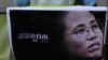 A protester displays a picture of the widow of late Chinese Nobel Peace laureate Liu Xiaobo, Liu Xia, during a demonstration outside the Chinese liaison office in Hong Kong, July 13, 2017.