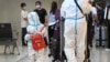 Des voyageurs portant des équipements de protection individuelle arrivent à l'aéroport de Melbourne, en Australie, le 29 novembre 2021.