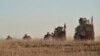 FILE - Turkish and U.S. troops conduct joint patrols around the Syrian town of Manbij, Nov. 1, 2018.