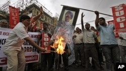 Activists of Socialist Unity Center of India (SUCI) burn an effigy with a portrait of Indian Prime Minister Manmohan Singh during a protest in Kolkata, India, September 15, 2012.