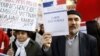 FILE - Turkish citizens in France, one of them holding a booklet reading "Electoral card," demonstrate in front of the Senate to protest against a law that would make it a crime to deny "genocide" of Armenians, in Paris, Jan. 23, 2012.