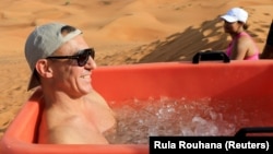 A participant sits in an ice bucket during an ice bath therapy session at the desert near Sharjah, United Arab Emirates, June 25, 2021. Picture taken June 25, 2021. 