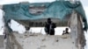 FILE - An Afghan security man stands guard at police station after clashes between the Afghan police and Taliban militants at a police station in the city of Kandahar, south of Kabul, Afghanistan, Dec. 8, 2015.