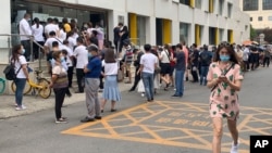 People wearing protective face masks to help curb the spread of the new coronavirus line up outside a health checkup center to get a nucleic acid test in Beijing, Monday, June 15, 2020. China's capital was bracing Monday for a resurgence of the…