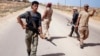 FILE - Libya Dawn fighters search for Islamic State militant positions during a patrol near Sirte.