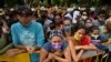 FILE - Venezuelan migrants wanting to return to their country due to the novel coronavirus COVID-19 pandemic, wait in Cali, Colombia, for a chance to get into a bus that will take them to the border, on May 12, 2020. 
