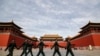 Soldiers wearing protective face masks march past the closed entrance gates to the Forbidden City, usually crowded with tourists before the new coronavirus outbreak in Beijing, March 12, 2020.
