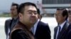 FILE - A man believed to be Kim Jong Nam, the eldest son of North Korean leader Kim Jong Il, looks at a battery of photographers as he exits a police van to board a plane to Beijing at Narita International Airport, northeast of Tokyo, May 4, 2001. 