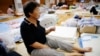 An evacuee uses a paper fan as she rests at Okada elementary school that is used as an evacuation center in Mabi town in Kurashiki, Okayama Prefecture, Japan, July 12, 2018.