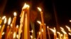 FILE - A man lights candles during a religious service marking the anniversary of mass killings of Armenians in Ottoman Empire in 1915 at an Armenian church in Tbilisi, Georgia.