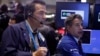 Trader Gregory Rowe, left, and specialist Anthony Rinaldi work on the floor of the New York Stock Exchange, Oct. 7, 2013.