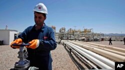 FILE - An employee works at Tawke oil fields in northern Iraq's Kurdish region.