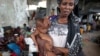 FILE - An internally displaced woman holds her malnourished son at a new settlement, Mogadishu, July 19, 2011.