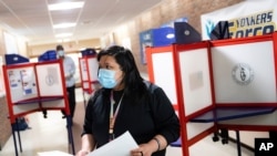 Una votante utiliza un tapabocas al ir a votar durante las elecciones primarias en Nueva York.