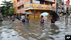 দক্ষিণ ভারতের তামিলনাড়ু রাজ্যের রাজধানী চেন্নাইয়ের একটি প্লাবিত রাস্তা দিয়ে হেঁটে যাচ্ছে মানুষ।