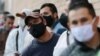 Workers wearing face masks amid the new coronavirus line up to enter the Corabastos market, one of Latin America's largest food distribution centers in the Kennedy area of Bogota, Colombia, June 1, 2020. 
