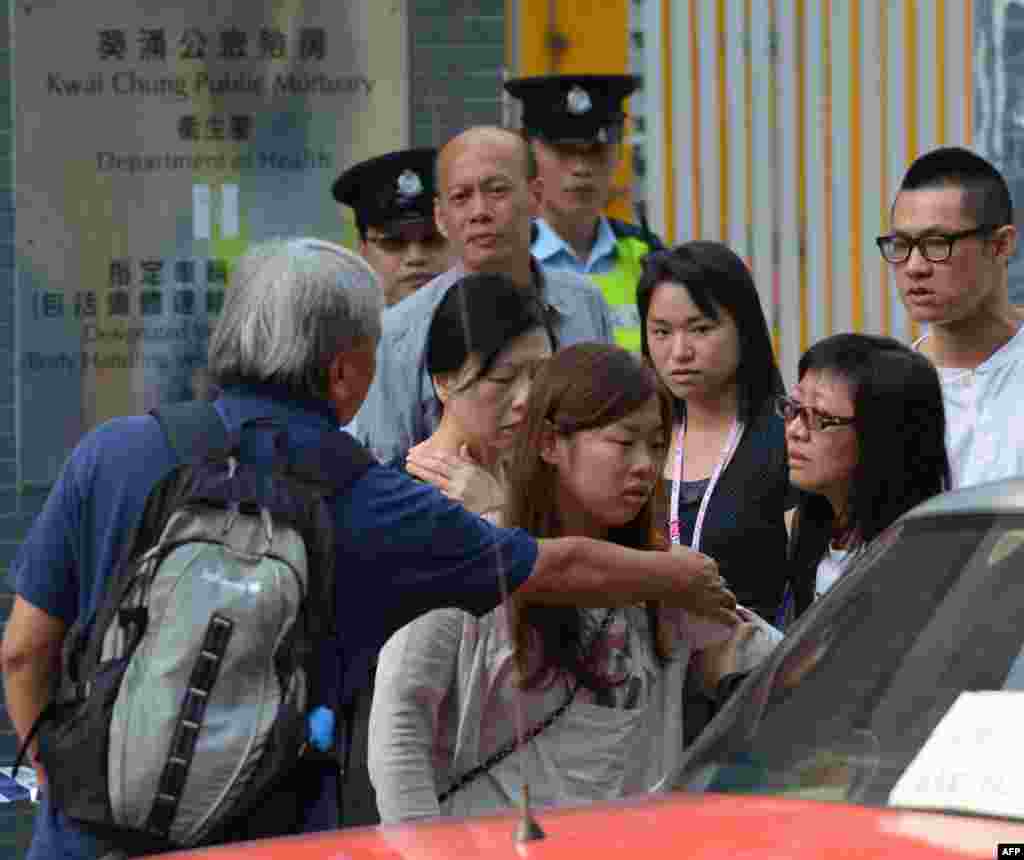 一名在两船相撞事件中死难者的家属2012年10月2日在确认死难者身份之后,离开葵涌公众殓房(AP)。