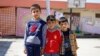 Displaced Iraqi boys pose at the Bilad al-Arab Elementary School, which has been turned into a housing complex for almost 31 families who fled Mosul because of Islamic State violence, in Baghdad, Oct. 22, 2014.