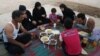 Syrian refugee family members break their fasting outside their tent at a refugee camp in the eastern town of Marj in Bekaa valley, Lebanon, June 29, 2014. 