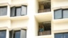 A foreign worker talks on the phone outside his room at the WestLite Toh Guan dormitory after it was declared an isolation area under the Infectious Diseases Act, following a spike in the number of COVID-19 cases in several foreign worker dormitories.
