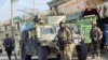 Afghan security forces keep watch in front of their armoured vehicle in Kunduz city, Afghanistan, Oct. 4, 2016. 