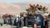 Syrian refugees, fleeing the recent fighting in Arsal, wait by trucks in Majdel Anjar in the Bekaa valley, near the Lebanese border with Syria, Aug. 8, 2014.