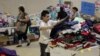 A migrant child chooses clothing at the Sacred Heart Catholic Church temporary migrant shelter in McAllen, Texas, June 27, 2014. 