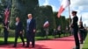First lady Melania Trump, President Donald Trump, French President Emmanuel Macron and Brigitte Macron, watch a flyover during a ceremony to commemorate the 75th anniversary of D-Day at the American Normandy cemetery, Thursday, June 6, 2019, in Colleville