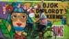Seorang pengendara sepeda melewati mural yang memperingatkan warga tentang pandemi Covid-19 di sepanjang jalan di Surabaya, 30 November 2020. (Foto: Juni Kriswanto / AFP)