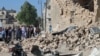 Residents look at the damage at a site hit by what activists said was a barrel bomb dropped by forces of Syria's President Bashar al-Assad, in the old city of Aleppo, May 31, 2015.
