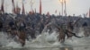 Indian Hindu holy men run naked into the water at Sangam, the confluence of the rivers Ganges, Yamuna and mythical Saraswati, during the royal bath at the start of the Kumbh Mela in Allahabad, India, Janaury 14, 2013.