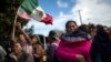 La migrante hondureña Leticia Nunes sostiene a su hija Mailyn junto a un pequeño grupo de migrantes que intentaron pasar el cruce fronterizo de Chaparral en Tijuana, México, el jueves 22 de noviembre de 2018.