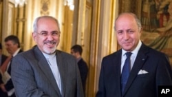 French foreign minister Laurent Fabius, right, poses for photographers with his Iranian counterpart Jawad Zarif prior to their meeting at the Quai d'Orsay in Paris, France, Nov. 5, 2013.
