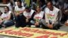 Kurds sit next to a banner that reads 'government, take steps' after Kurdish rebels gave Turkey a 'final warning' to take steps that would move forward peace talks aimed at ending a 30-year old conflict that has claimed tens of thousands of lives, in Anka