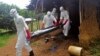 Ebola health care workers carry the body of a middle aged man they suspected of dying from the Ebola virus on the outskirts of Monrovia, Liberia, Nov. 8, 2014. 