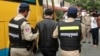 A Chinese national arrested over an alleged internet scam is escorted by police officers to be deported at the immigration office in Phnom Penh, Cambodia, July 26, 2017. 