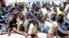 FILE - Illegal migrants sit at a naval base after they were rescued by Libyan coastguard in the coastal city of Tripoli, Libya, May 6, 2017. 