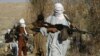 FILE - Taliban fighters carry weapons in an undisclosed location in Nangarhar province.