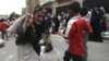 FILE - A man carries food aid provided by the Red Crescent Society in Sana'a.