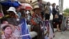 A Boeung Kak lake community's land activist, left, holds a poster of detained Tep Vanny as she joins together with the others to deliver petition to the Justice Ministry, in Phnom Penh, Cambodia, Wednesday, Jan. 4, 2017. The villagers of Boeung Kak lake community staged a protest to demand the release of detained land rights activist Tep Vanny, who was sentenced last August to six months in prison. Phnom Penh's Boueng Kak is a lake area the government awarded to a Chinese company for commercial development, including a hotel, office buildings and luxury housing. (AP Photo/Heng Sinith)