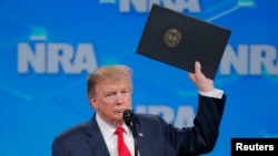 Lokacin da shugaba Trump a lokacin da ya saka hannu kan wata doka da ta fitar da Amurkja daga yarjejeniyar makamai ta Majalisar Dinkin Duniya
