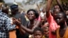 FILE - Women and children refugees cheers the motorcade carrying Central African Republic's interim President Catherine Samba-Panza during her visit to refugee camps in Bangui, Central African Republic, Feb. 1, 2014. 