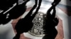 FILE - Shadows of tourists are cast across a papal crest dedicated to Pope Pius XII on the floor of Saint Peter's Basilica at the Vatican, March 11, 2013. 